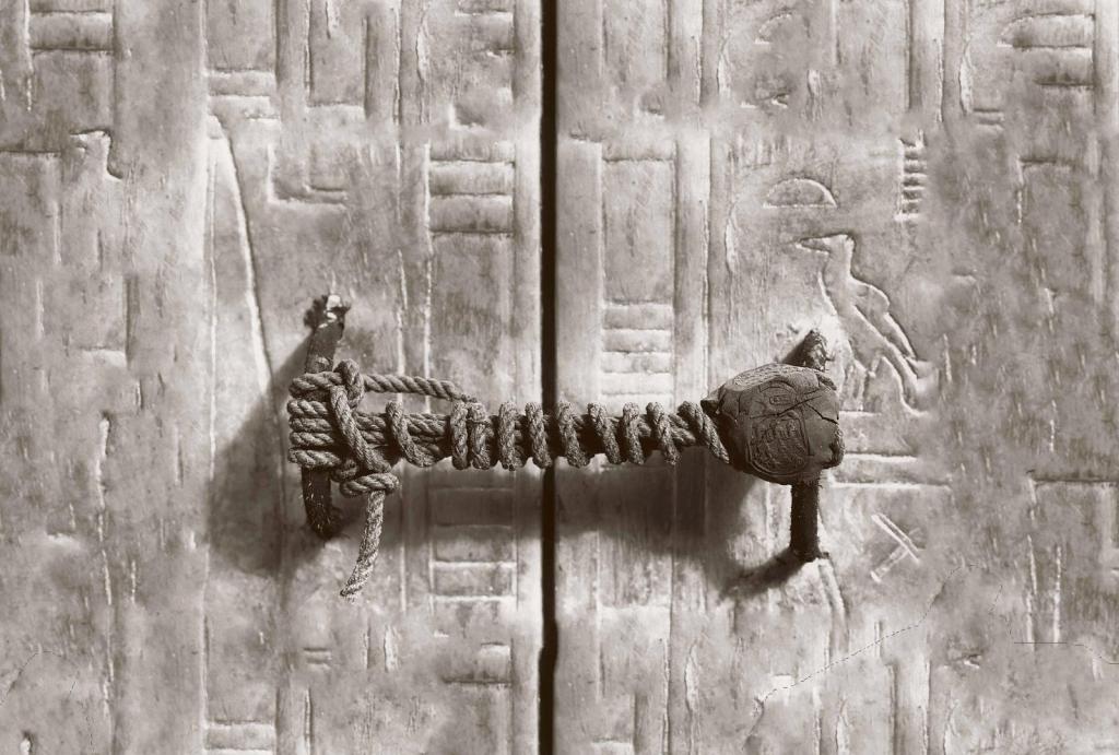 Doorway to the tomb of Tutankhamun with hieroglyphs on the surface. The door seal, including tied ropes and dried clay, is still intact.