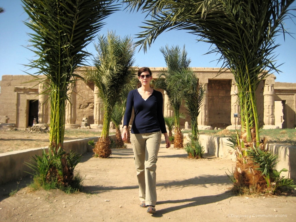Woman walking towards the camera in front of an ancient Egyptian temple